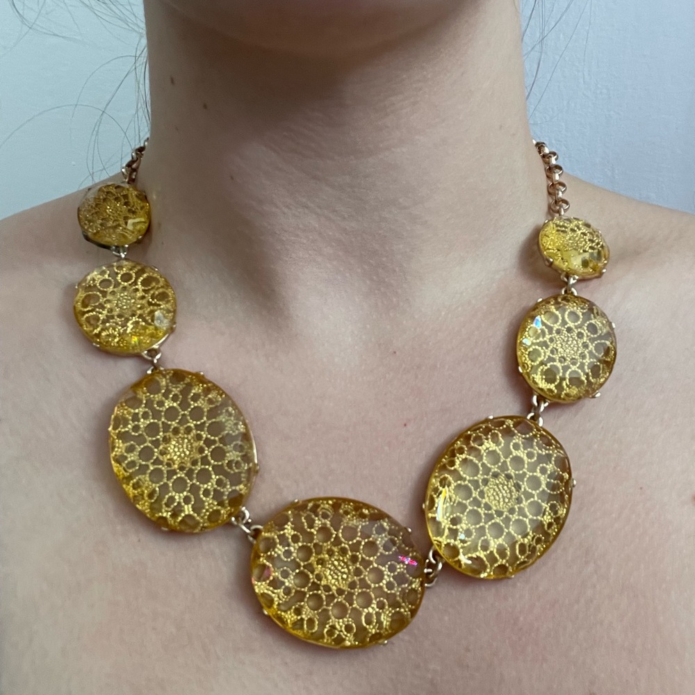 Gold colored necklace with glass